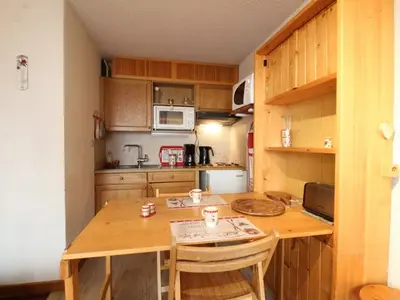 a small kitchen with a wooden table and chairs at Appartement rénové 2P 4 pers, proche pistes et commerces - FR-1-572-20 in Arâches-la-Frasse