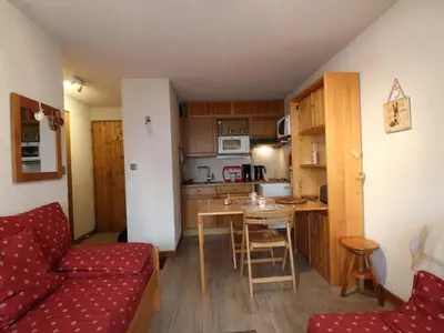 a living room with a red couch and a kitchen at Appartement rénové 2P 4 pers, proche pistes et commerces - FR-1-572-20 in Arâches-la-Frasse