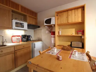 a kitchen with a wooden table and a kitchen with a tableablish at Appartement rénové 2P 4 pers, proche pistes et commerces - FR-1-572-20 in Arâches-la-Frasse