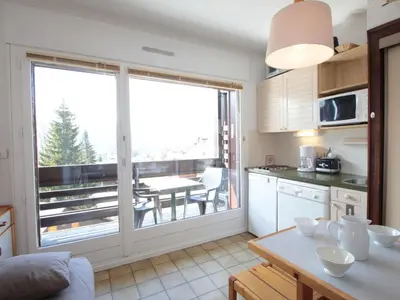 a kitchen with a table and a dining room with a balcony at Studio cosy 4 pers. au pied des pistes avec balcon - Proche centre et commodités - FR-1-572-151 in Arâches-la-Frasse