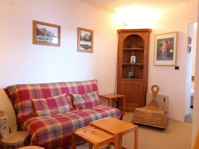 a living room with a couch and a table at 2P tout confort face aux pistes, proche commerces, 6 couchages, balcon S-E, parking, casier à skis - FR-1-572-97 in Arâches-la-Frasse