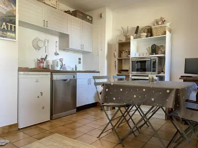 a kitchen with a table and chairs in a room at Studio 4 pers. au pied des pistes, balcon, parking, Wi-Fi, proche commerces - FR-1-572-238 in Arâches-la-Frasse