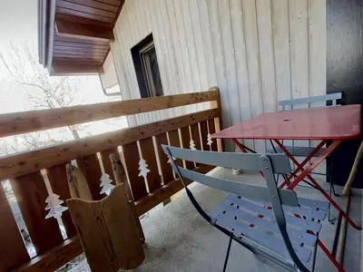 a table and a chair on a porch at Studio 4 pers. au pied des pistes, balcon, parking, Wi-Fi, proche commerces - FR-1-572-238 in Arâches-la-Frasse
