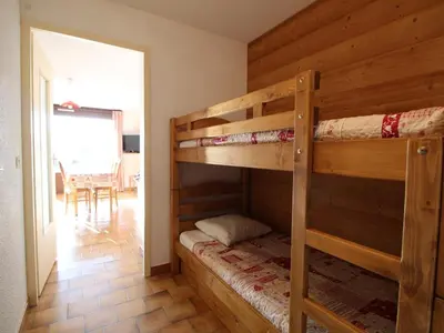 a bedroom with two bunk beds and a dining room at Studio spacieux 4 pers avec garage, lave-vaisselle aux Carroz - FR-1-572-159 in Arâches-la-Frasse