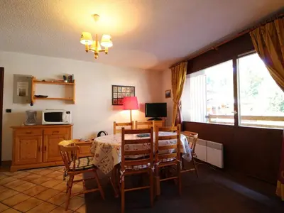 a kitchen and dining room with a table and chairs at 3 pièces pour 6 personnes face aux pistes et commerces, stationnement inclus - FR-1-572-190 in Arâches-la-Frasse