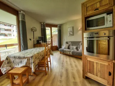a living room with a kitchen and a living room with a couch at Bel appartement familial aux pieds des pistes - FR-1-642-73 in Morillon