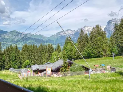 a cabin in a field with mountains in the background at Bel appartement familial aux pieds des pistes - FR-1-642-73 in Morillon