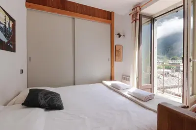 a bedroom with a white bed with a large window at Nook 40 - Les Balances - Central Mont-Blanc views in Chamonix-Mont-Blanc