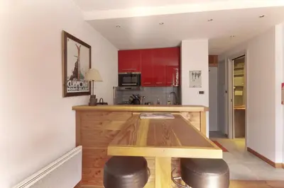 a kitchen with a wooden table and red cabinets at Nook 40 - Les Balances - Central Mont-Blanc views in Chamonix-Mont-Blanc