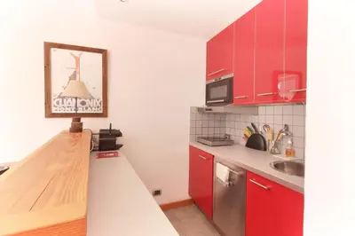 a kitchen with red cabinets and a counter top at Nook 40 - Les Balances - Central Mont-Blanc views in Chamonix-Mont-Blanc
