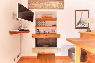 a living room with a fireplace in the corner at Nook 40 - Les Balances - Central Mont-Blanc views in Chamonix-Mont-Blanc