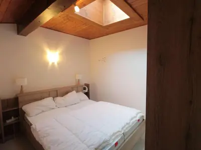 a bedroom with a white bed with a wooden ceiling at Appartement Duplex 4 pièces pour 6 pers, sur les pistes avec WiFi et parking, proche commerces - FR-1-572-62 in Arâches-la-Frasse
