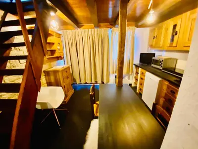 a kitchen with a table and a staircase in a room at Appartement face Mont Blanc in Demi-Quartier
