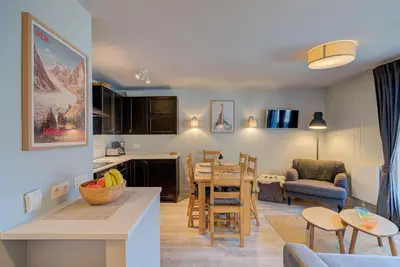 a kitchen and living room with a table and chairs at Apartment Fermes du Montenvers B2- Alpes Travel - Central Chamonix (sleeps 4-5) in Chamonix-Mont-Blanc