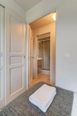 a bedroom with a bed and a closet with a door at Apartment Fermes du Montenvers B2- Alpes Travel - Central Chamonix (sleeps 4-5) in Chamonix-Mont-Blanc