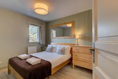 a small bedroom with a bed and a mirror at Apartment Fermes du Montenvers B2- Alpes Travel - Central Chamonix (sleeps 4-5) in Chamonix-Mont-Blanc