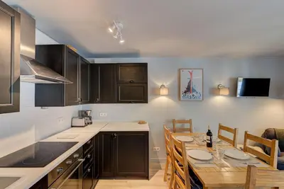 a kitchen with a table and a dining room at Apartment Fermes du Montenvers B2- Alpes Travel - Central Chamonix (sleeps 4-5) in Chamonix-Mont-Blanc