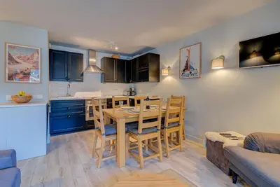 a kitchen with a table and chairs in a room at Apartment Fermes du Montenvers B2- Alpes Travel - Central Chamonix (sleeps 4-5) in Chamonix-Mont-Blanc