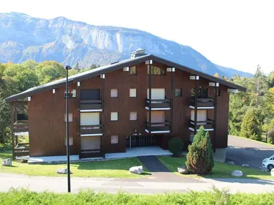 a large building with a mountain in the background at Studio 4 pers à 100m des pistes, proche commerces - FR-1-572-219 in Arâches-la-Frasse