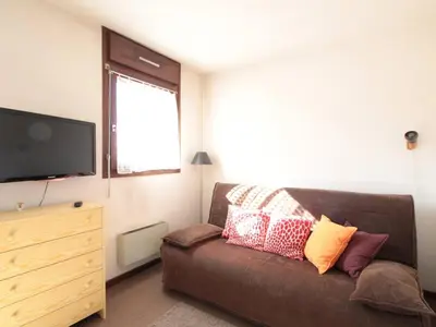 a living room with a brown couch and a flat screen tv at Studio 4 pers à 100m des pistes, proche commerces - FR-1-572-219 in Arâches-la-Frasse
