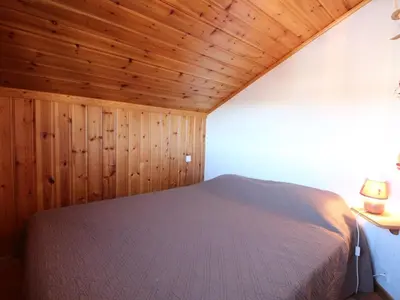 a bedroom with a bed in a room with wooden walls at Appartement Mansardé 3 Pièces, 6 Pers, Balcon Sud-Est, Garage, Proche Centre et Pistes - FR-1-572-147 in Arâches-la-Frasse