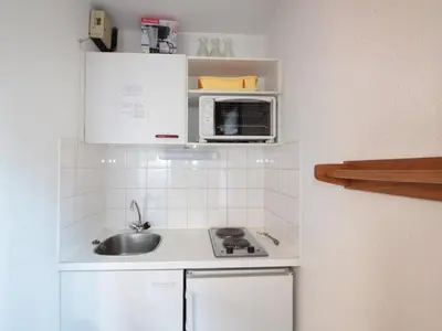 a small kitchen with a sink and a microwave at Studio central village aux Carroz, animaux admis, 5 pers - FR-1-572-202 in Arâches-la-Frasse