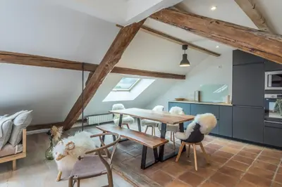 a dining room with a wooden table and chairs at Appartement Soffitta - Welkeys in Chamonix-Mont-Blanc