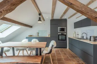 a kitchen with a wooden table and chairs at Appartement Soffitta - Welkeys in Chamonix-Mont-Blanc