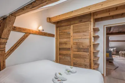 a bedroom with a bed and a wooden wall at Appartement Soffitta - Welkeys in Chamonix-Mont-Blanc