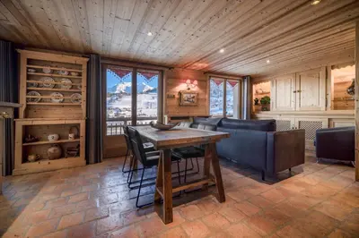 a dining room with a table and a couch at Chalet Nessa in Combloux