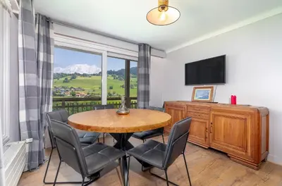a dining room with a table and chairs and a window at Chalet Nessa in Combloux