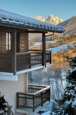a cabin with a balcony with a view of the mountains at Chalet Nessa in Combloux