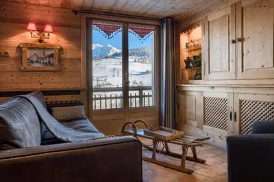 a living room with a couch and a large window at Chalet Nessa in Combloux