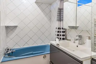 a bathroom with a sink and a blue tub at Appartement Lyret - Welkeys in Chamonix-Mont-Blanc