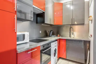 a kitchen with orange and silver cabinets and a dishwasher at Appartement Lyret - Welkeys in Chamonix-Mont-Blanc