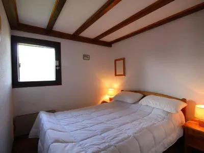 a bedroom with a large white bed with two lamps at Appartement cosy 6 pers. au pied des pistes, balcon sud-ouest, proche centre, ski-in/ski-out - FR-1-572-155 in Arâches-la-Frasse