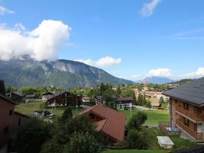 a view of a town with a mountain in the background at Appartement cosy 6 pers. au pied des pistes, balcon sud-ouest, proche centre, ski-in/ski-out - FR-1-572-155 in Arâches-la-Frasse