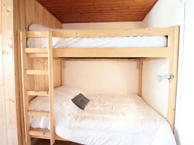 two bunk beds in a small room with a bed at Studio 4 pers, centre village, 450m télécabine, balcon, casier à skis, animaux acceptés - FR-1-572-211 in Arâches-la-Frasse