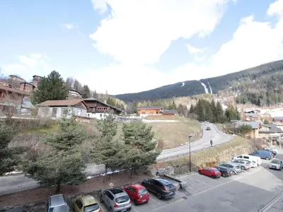 a bunch of cars parked in a parking lot at Studio 4 pers, centre village, 450m télécabine, balcon, casier à skis, animaux acceptés - FR-1-572-211 in Arâches-la-Frasse