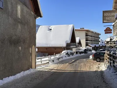 a snow covered street in a town with a building at Studio 4 pers, centre village, 450m télécabine, balcon, casier à skis, animaux acceptés - FR-1-572-211 in Arâches-la-Frasse