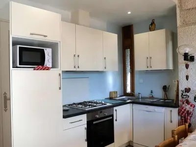 a kitchen with white cabinets and a stove and a microwave at Chalet 3 chambres, 8 pers, terrasse sud, proche remontées, équipements complets - FR-1-572-216 in Arâches-la-Frasse