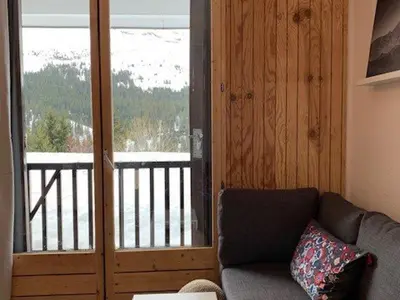 a living room with a couch and a sliding glass door at Studio rénové à Flaine Forêt - 5 pers, proche des pistes et commerces, balcon sud, casier à skis - FR-1-687-24 in Arâches-la-Frasse