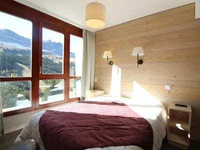 a bedroom with a large bed with a large window at Flaine: 4P au pied des pistes, piscine, parking, 8 pers - FR-1-687-15 in Arâches-la-Frasse
