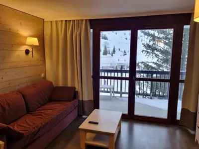 a living room with a couch and a sliding glass door at Flaine: 4P au pied des pistes, piscine, parking, 8 pers - FR-1-687-15 in Arâches-la-Frasse