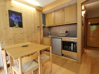 a kitchen with a wooden table in a room at Studio rénové 4 pers, Résidence Andromède, Flaine Forêt, à 300m des pistes et 140m des commerces - FR-1-687-26 in Arâches-la-Frasse
