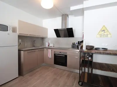 a kitchen with a white refrigerator and wooden floors at Appartement 3 pièces pour 6 personnes à 350m des pistes – Résidence Petite Ourse, Flaine Forêt - FR-1-687-16 in Arâches-la-Frasse