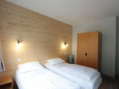 a bedroom with two beds and a wooden wall at Appartement 3 pièces pour 8 personnes aux pieds des pistes à Flaine - FR-1-687-44 in Arâches-la-Frasse