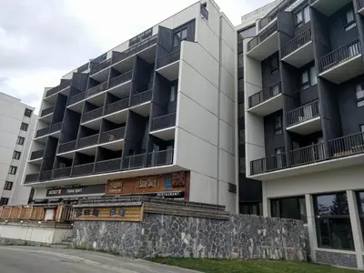 an apartment building with a stone wall in front of it at Appartement 3 pièces pour 8 personnes aux pieds des pistes à Flaine - FR-1-687-44 in Arâches-la-Frasse