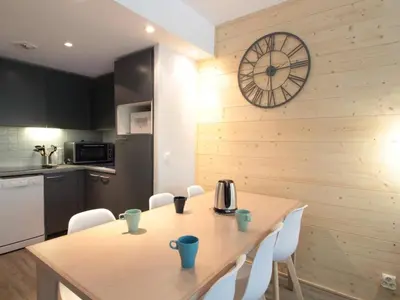 a kitchen with a table and a clock on a wall at Appartement 3 pièces pour 8 personnes aux pieds des pistes à Flaine - FR-1-687-44 in Arâches-la-Frasse