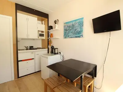 a small kitchen with a table and a small refrigerator at Studio confortable 4 pers, au pied des pistes de Flaine avec balcon - FR-1-687-28 in Arâches-la-Frasse